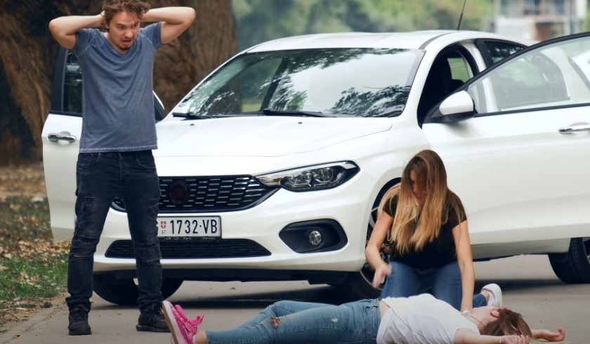Saobraćajna nesreća, vozač u neverici, devojka pruža drugoj osobi prvu pomoć